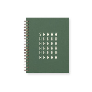 Notebook with green cover and white text says, "Shhhhhhhhhhhh" with coil binding.