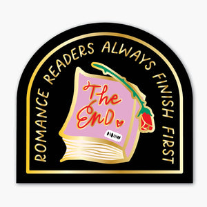 Sticker with black background and gold metallic effect with image of a pink book with a red rose and red and gold text says, "The end". Gold metallic text says, "Romance readers always finish first".