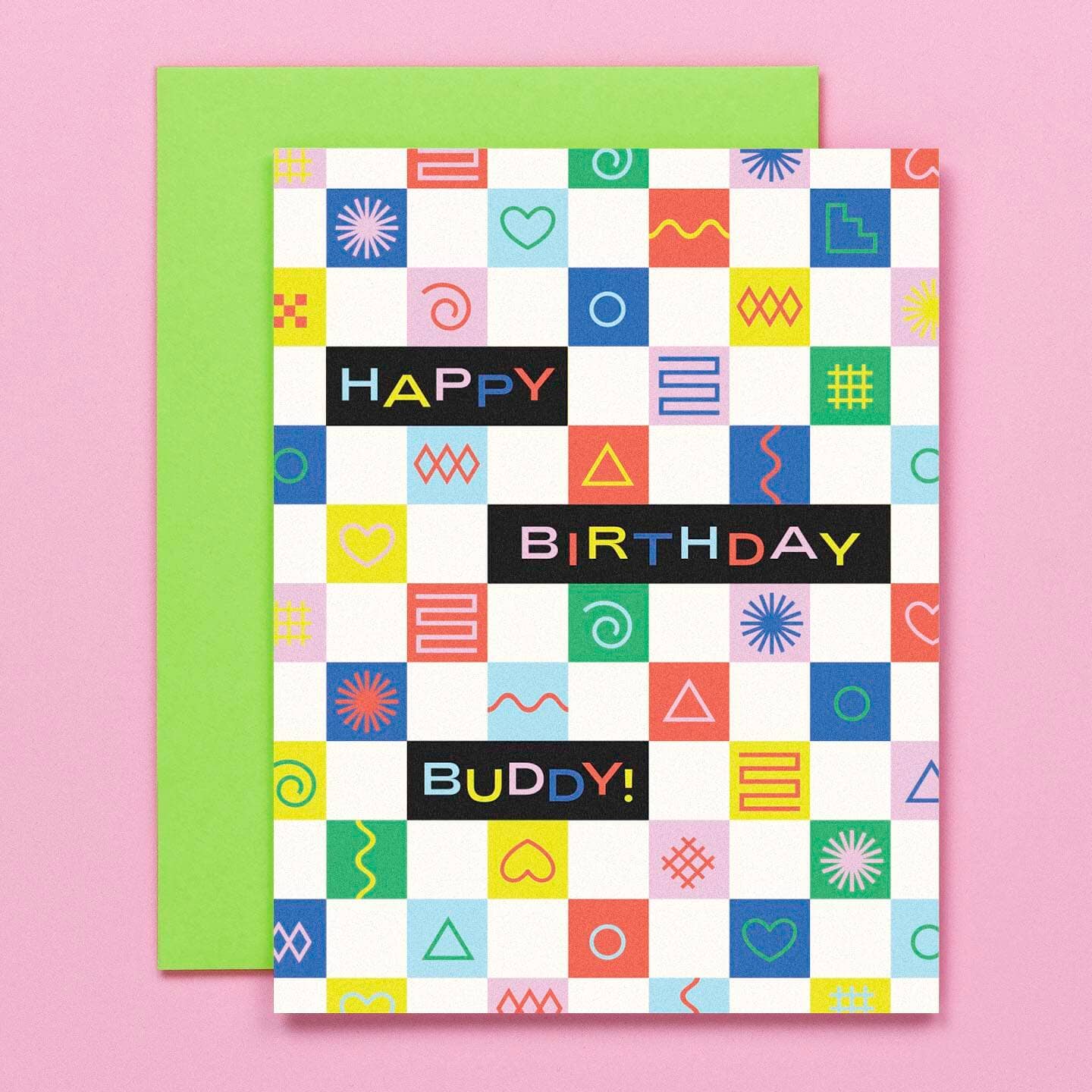 Greeting card with checkerboard background red, blue, white, green and yellow. Black rectangles with text says, "Happy Birthday Buddy!". Neon green envelope included. 