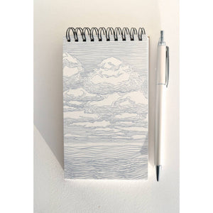 Notebook with black and white sketch of clouds on cover and coil binding at top. 