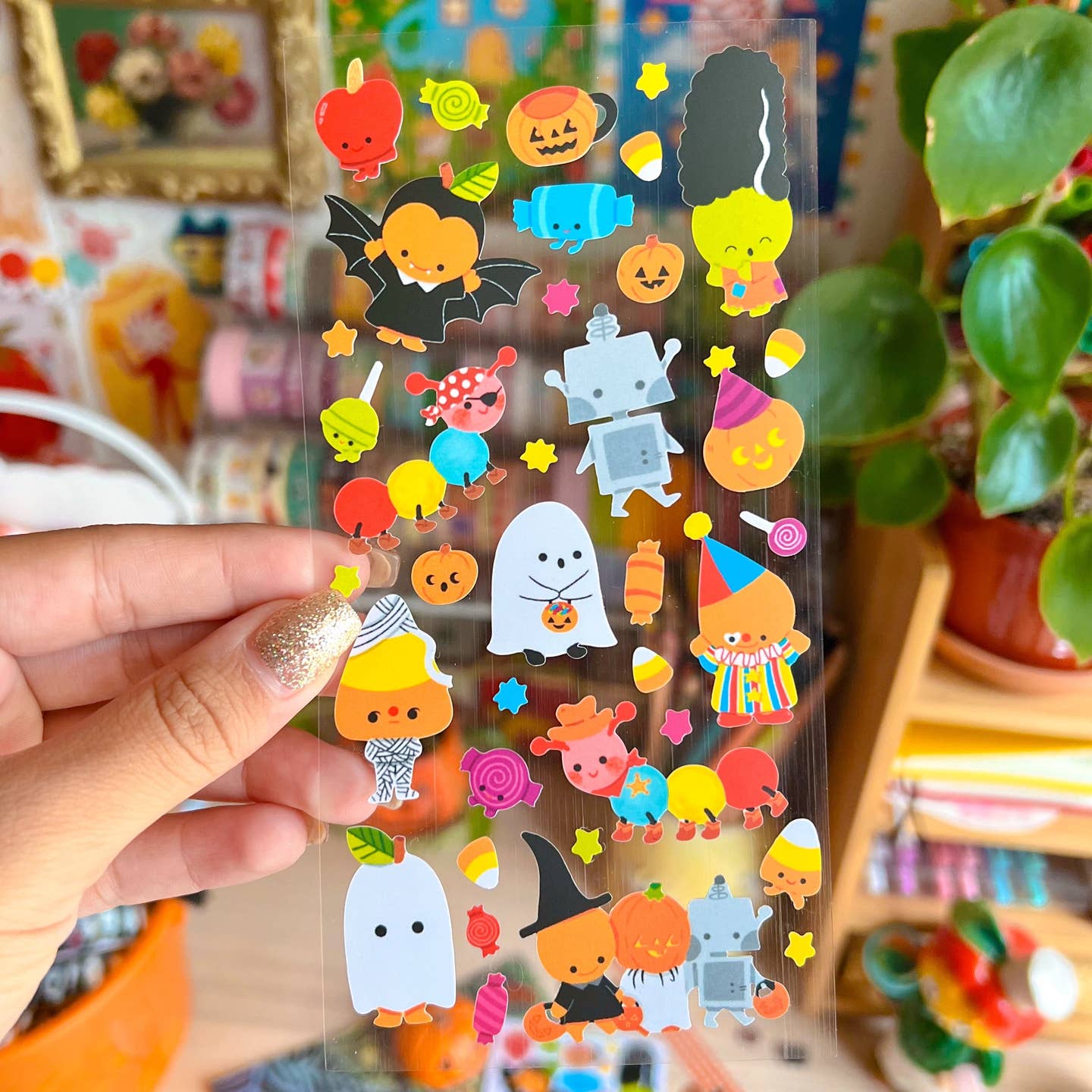 Decorative sticker sheet with clear background and images of ghosts, Frankenstein, Dracula and candy corn in costumes. 