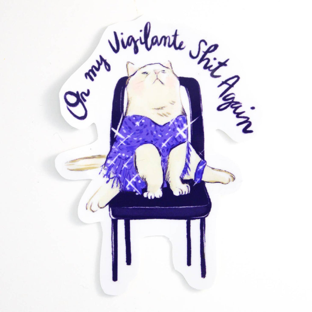 Image of sticker with white background and image of a white cat wearing a sparkly purple dress sitting on a black chair and purple text says, "On my vigilante shit again". 
