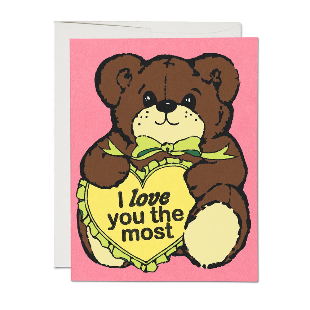 Greeting card depicting a big teddy bear holding a yellow heart with text that says "I love you the most"