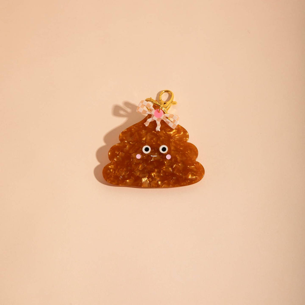 Image of a plastic charm in the shape of a little unchi and a pink checkered bow. 