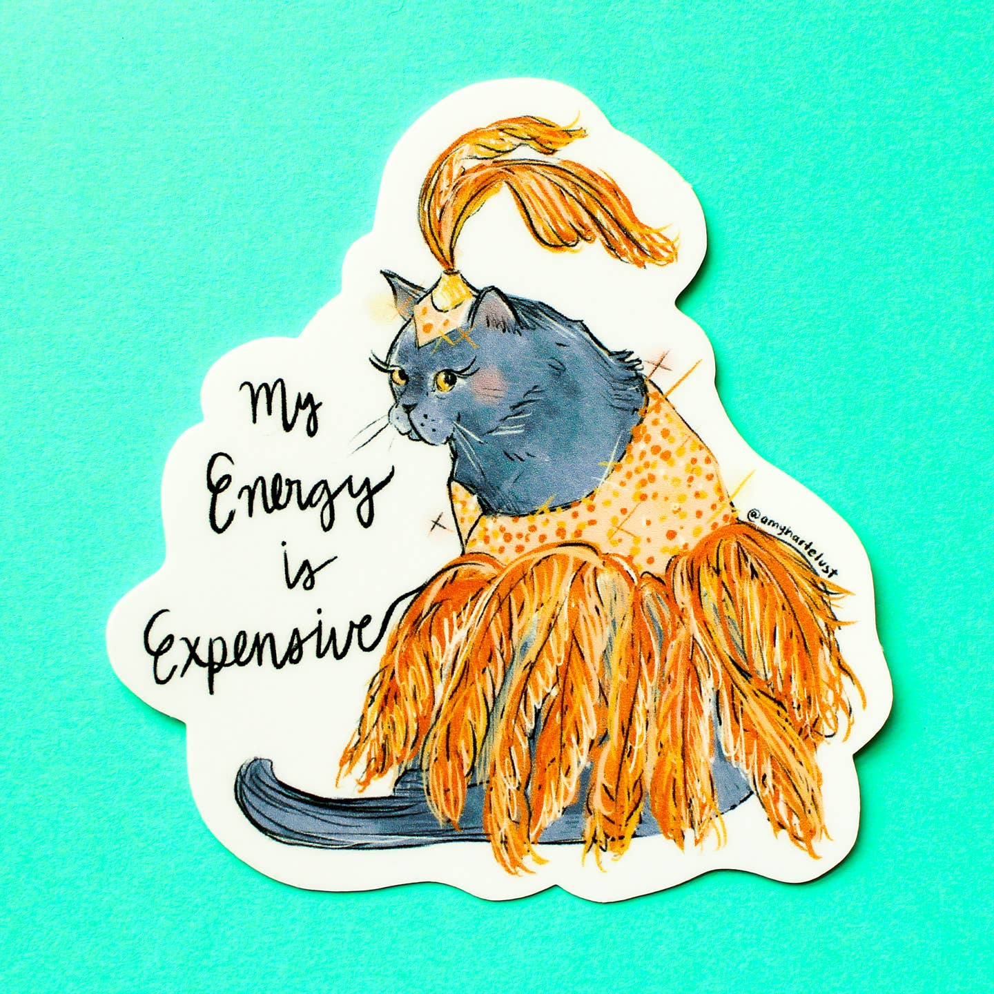 Decorative sticker with white background and image of a cat wearing an orange showgirl outfit with black text says, "My energy is expensive". 