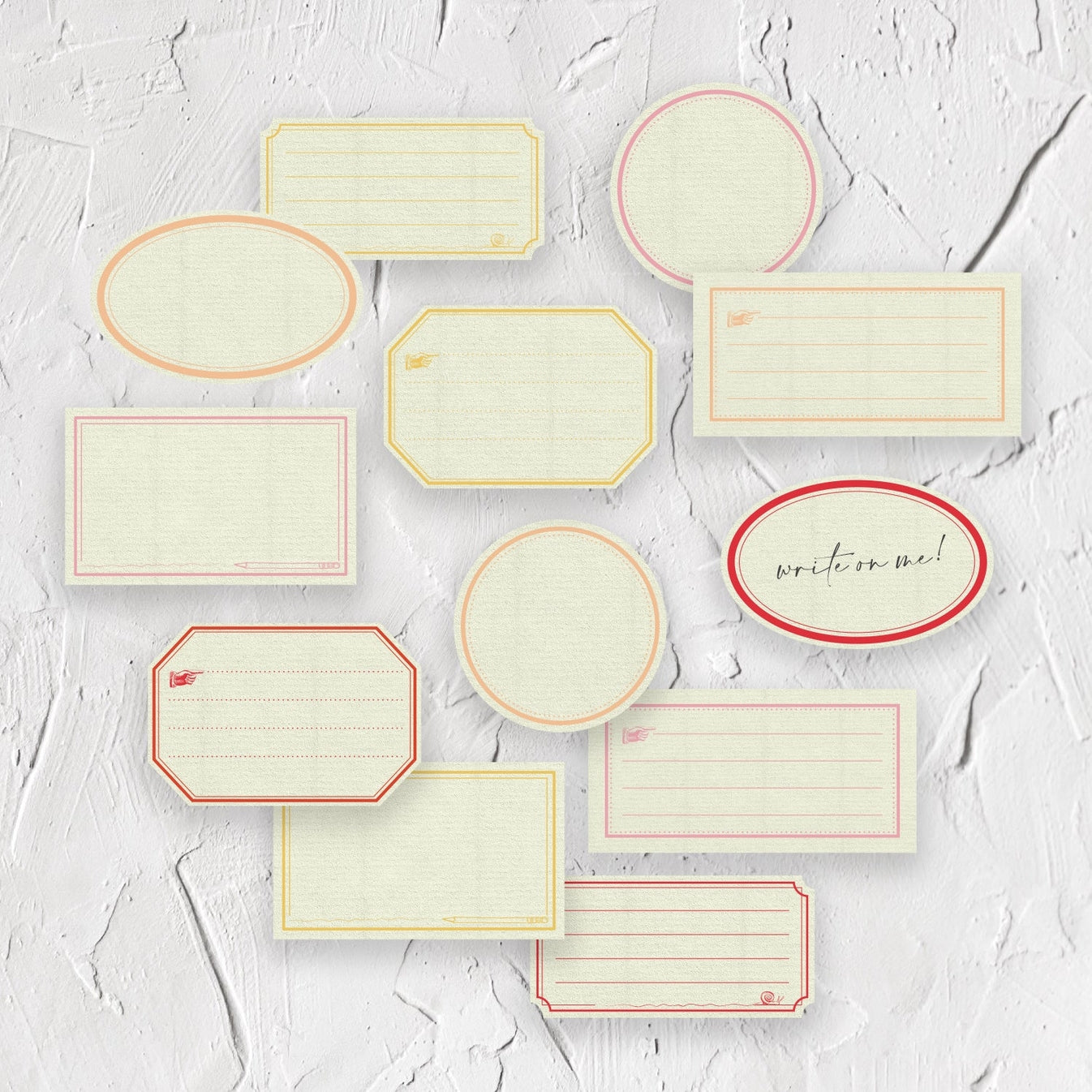 Decorative labels and box with cream background and borders in pink, red, peach and yellow.