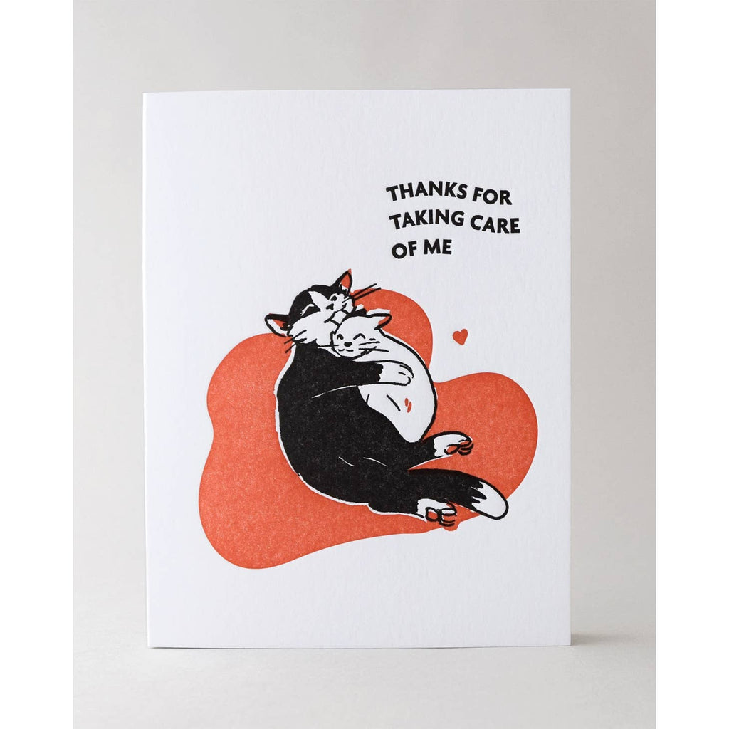 White background with image of red blob with a black and white cat holding and licking the head of a white cat. Black text says, "Thanks for taking care of me". Envelope is included. 