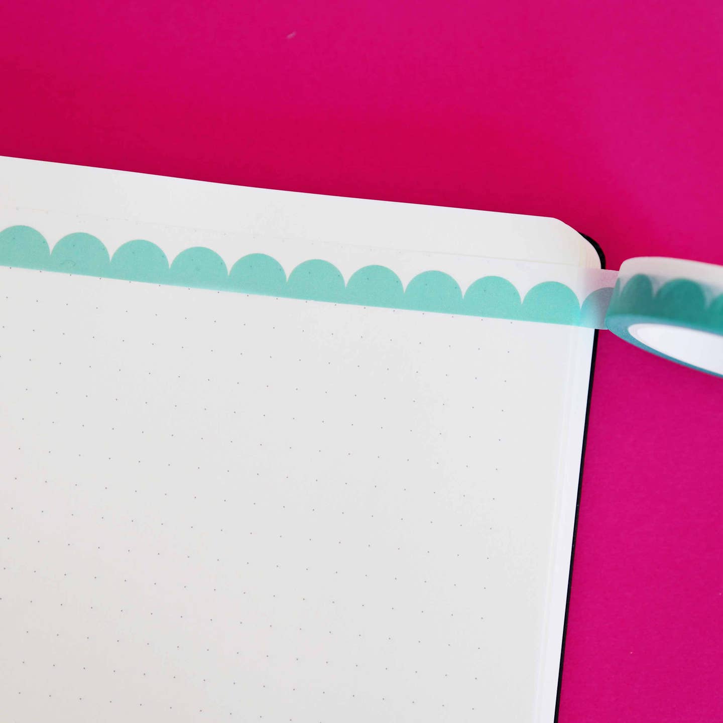 Washi tape with turquoise scalloped pattern and white edging.