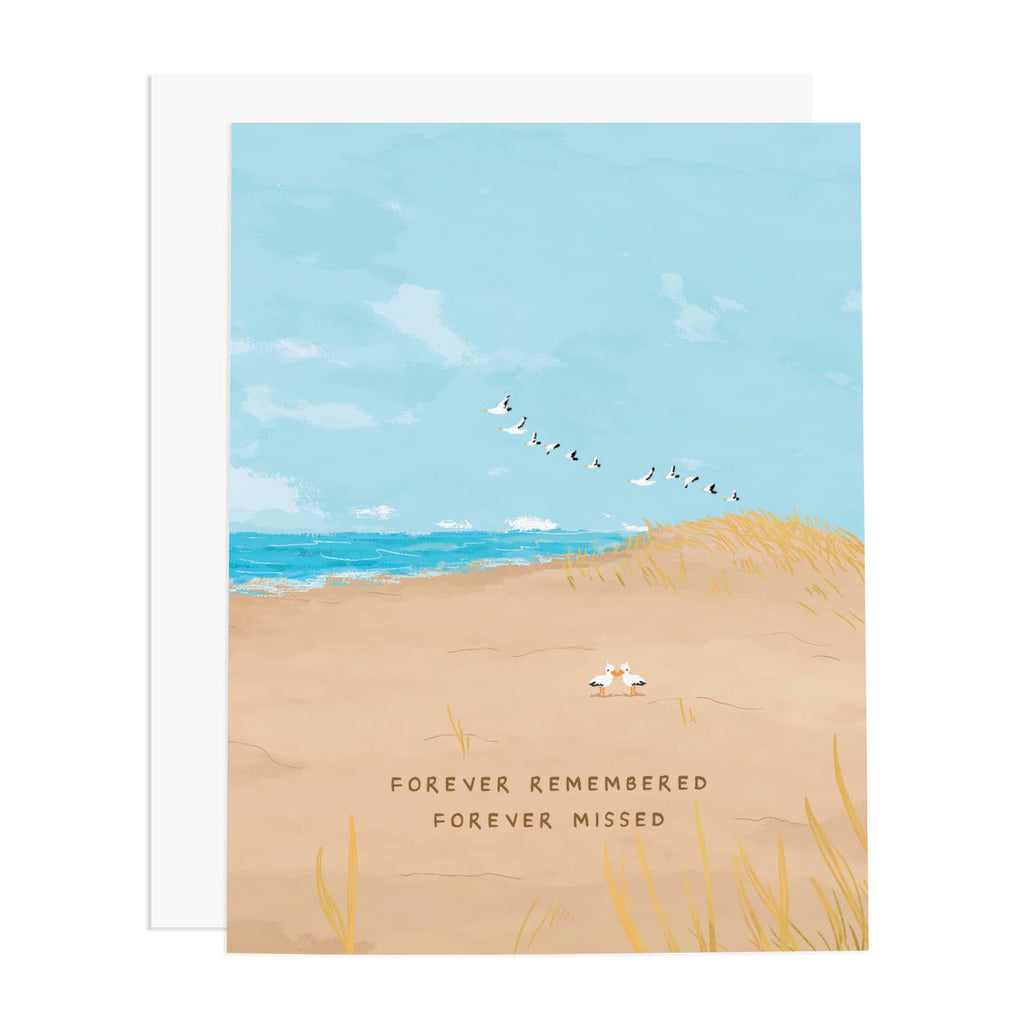 Greeting card with blue sky and tan sand with images of flying black and white birds with two birds on the beach, Brown text says, "Forever remembered, Forever missed". White envelope included. 