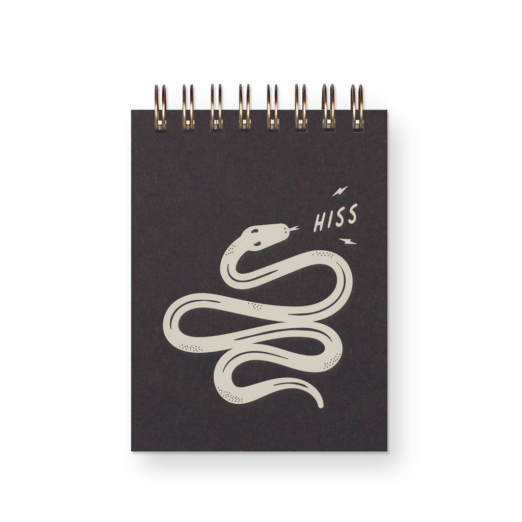 Pocket notebook with black cover and grey image of a snake with grey text says, "Hiss". Coiled binding at top.