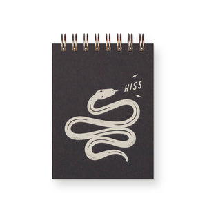 Pocket notebook with black cover and grey image of a snake with grey text says, "Hiss". Coiled binding at top.