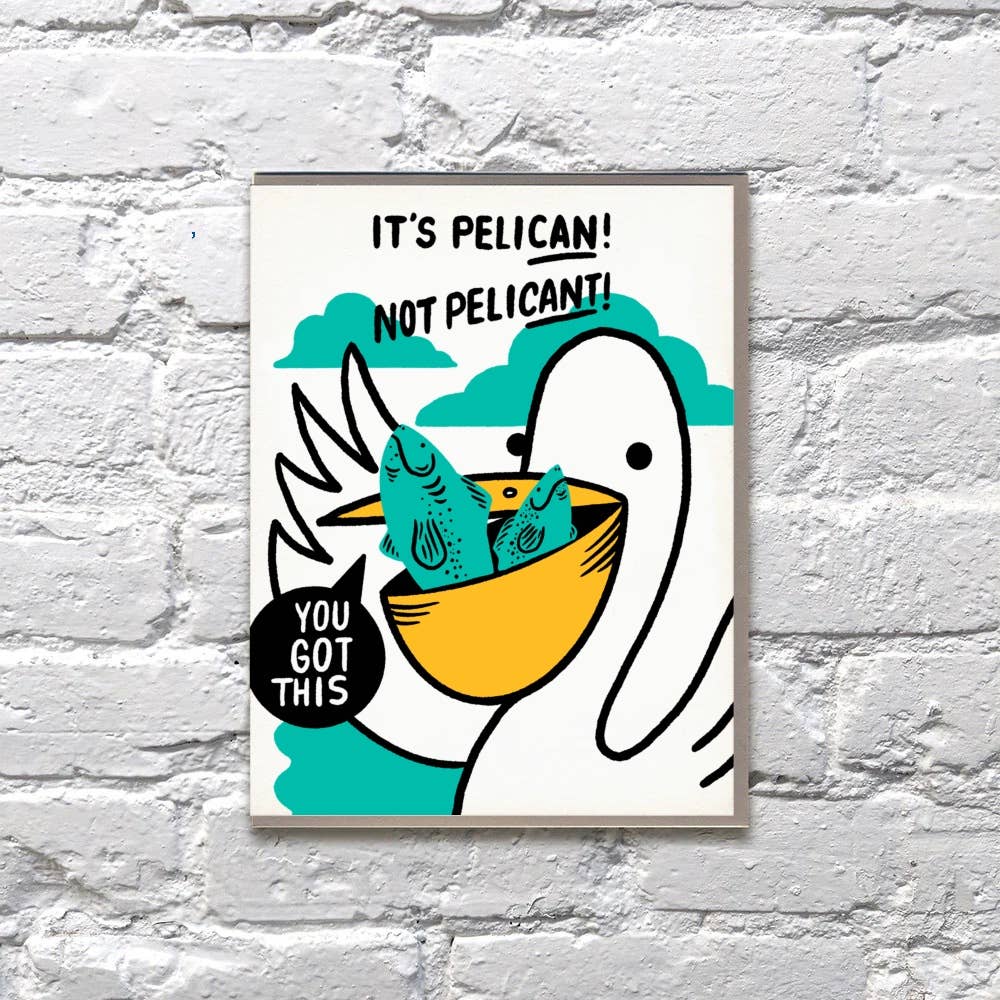Greeting card with white background and image of a pelican with two fish in its beak. Black text says, "It's pelican! Not Pelican't! You got this". Envelope included.
