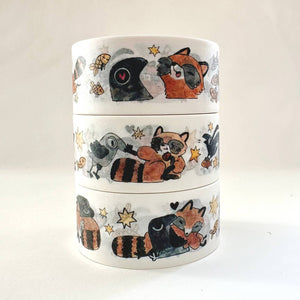 Image of washi tape with cream background with images of brown, white and black raccoons and black crows. 