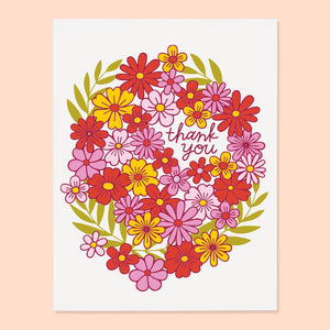 Greeting card with white background and image of wreath of flowers in pink, red, yellow with green leaves. Red text says, "Thank you". Envelope included. 