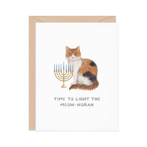 White background with images of cat with a menorah and black text says, "Time to light the meow-norah". Kraft envelope is included.
