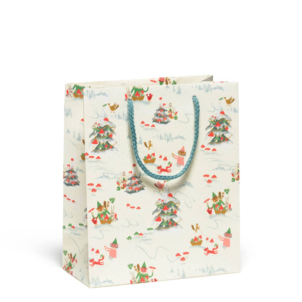 Gift bag with cream background and images of elves and critters in red green and cream. 