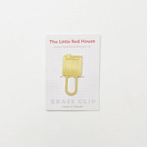 Image of brass clip bookmark with book at top. 