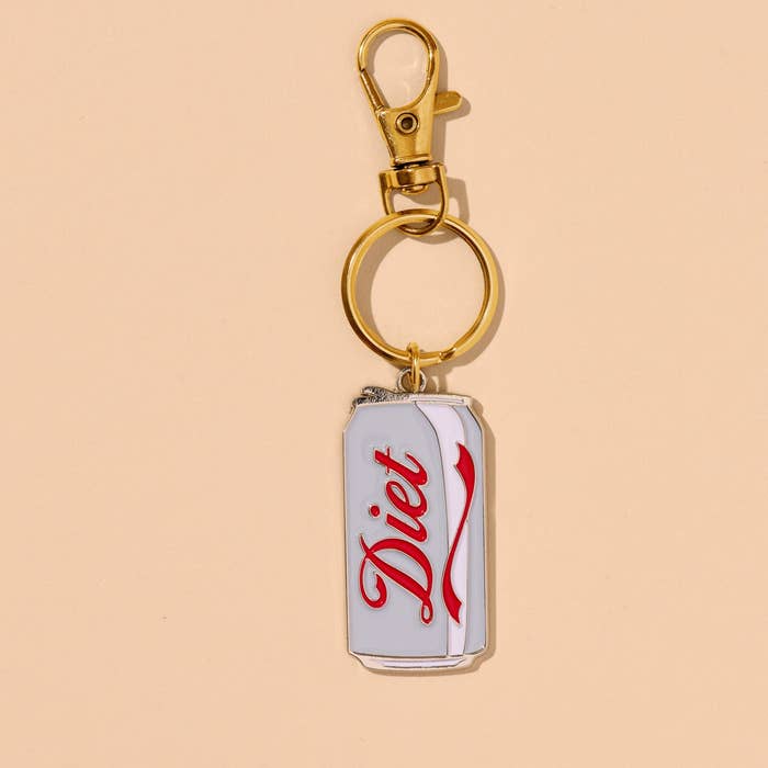 Image of keychain charm in the shape of a can of diet soda in red and white with gold ring and clip. 