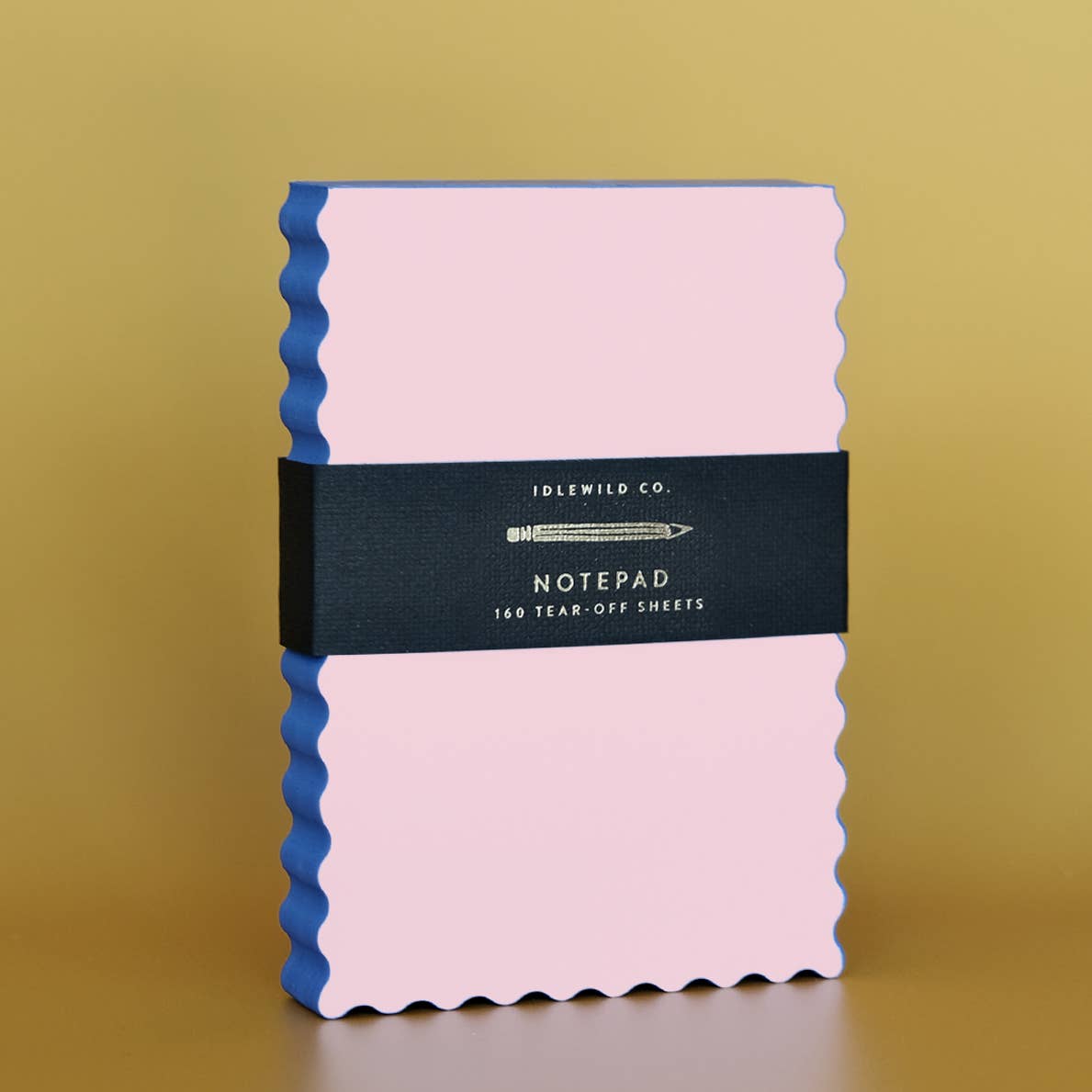 Notepad with peach paper and indigo wavy edging.