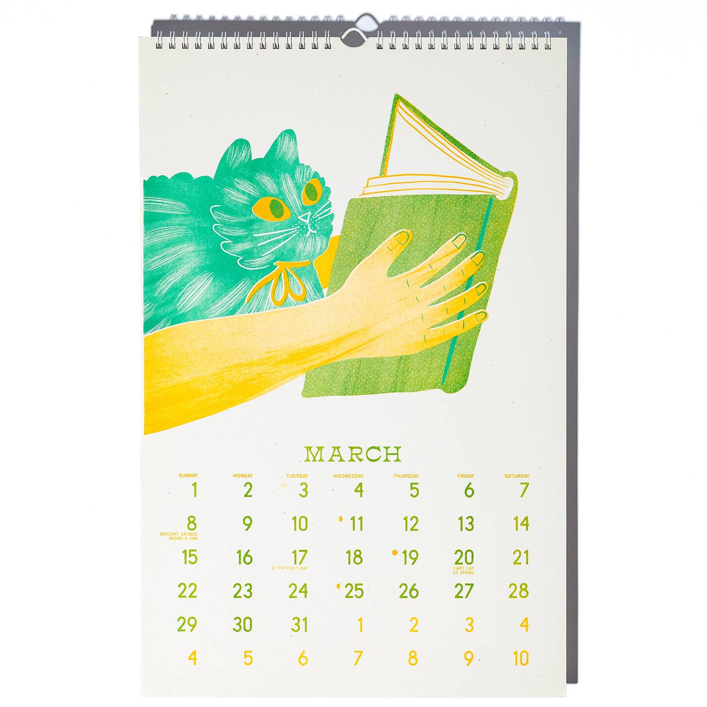 March  calendar page with image of a teal cat looking at the open book held by two yellow arms and hands.