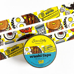 Decorative tape with yellow and white checked background and images of breakfast foods including bagels, coffee, eggs, toast and butter. 