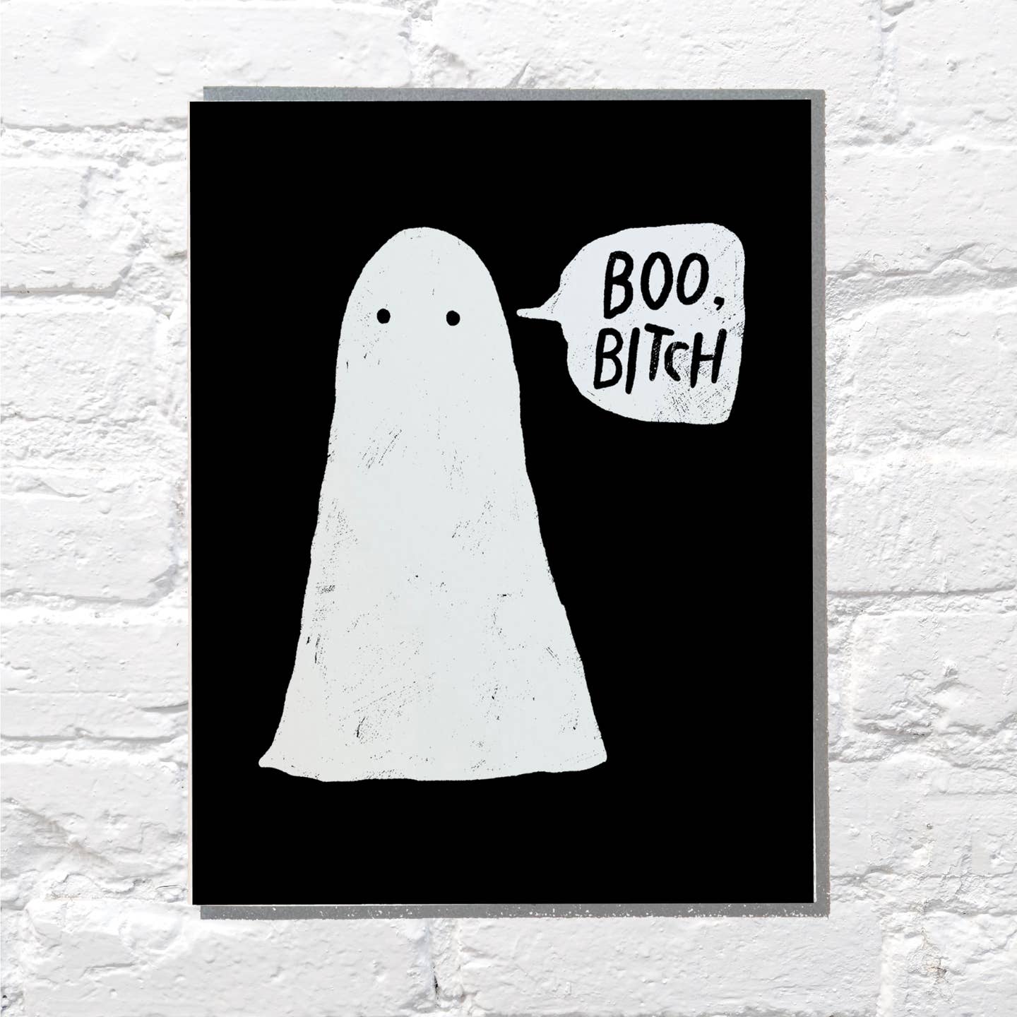Greeting card with black background and image of a white ghost with a word bubble with black text says, "Boo, bitch". Grey envelope included.