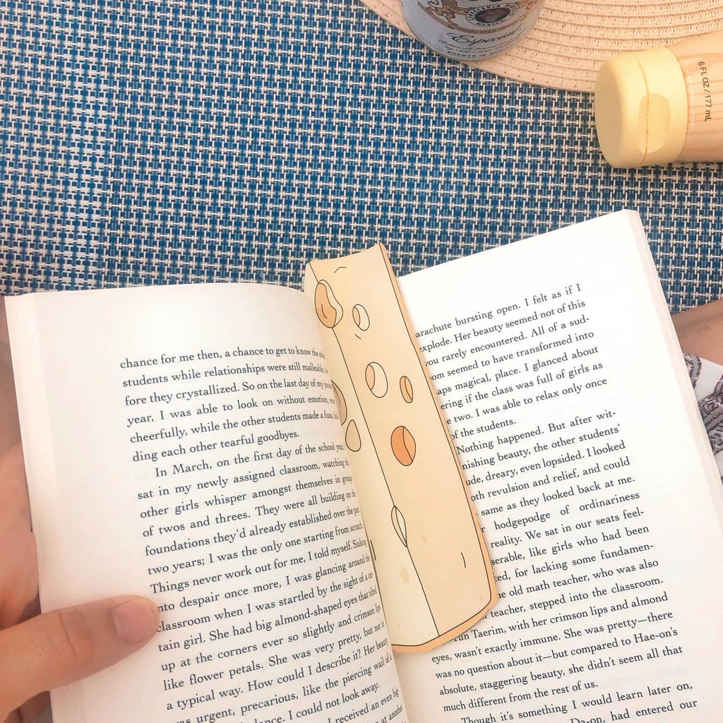 Image of bookmark shaped like a block of yellow cheese. 