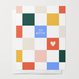 Greeting card with checkered background in white, red, yellow, green and pink. White text says, "Go Bestie!". Envelope included. 