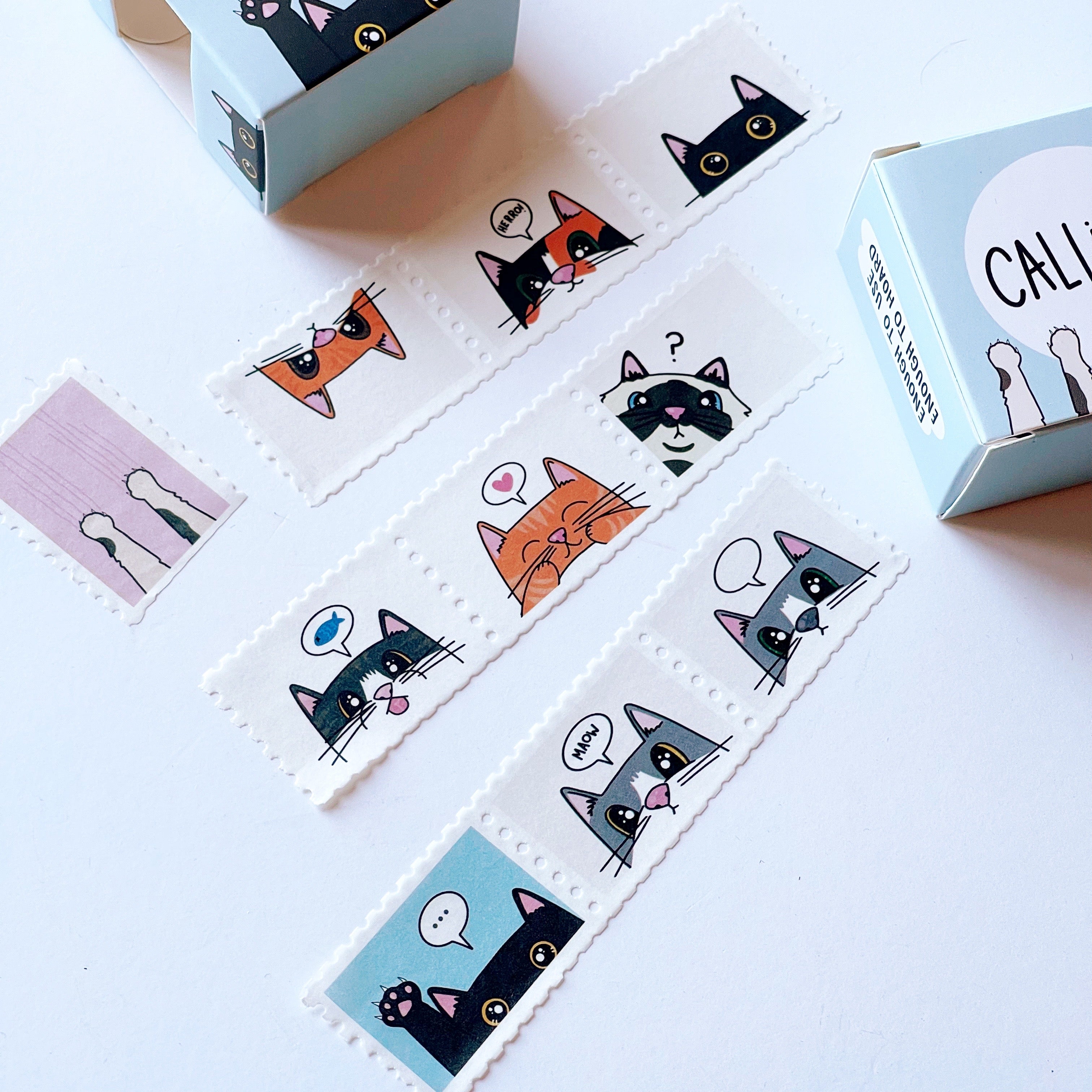 Image of stamp Washi tape with images of cats faces from the nose up with word bubbles with black text says, "meow" or has images of fish, hearts or "...".