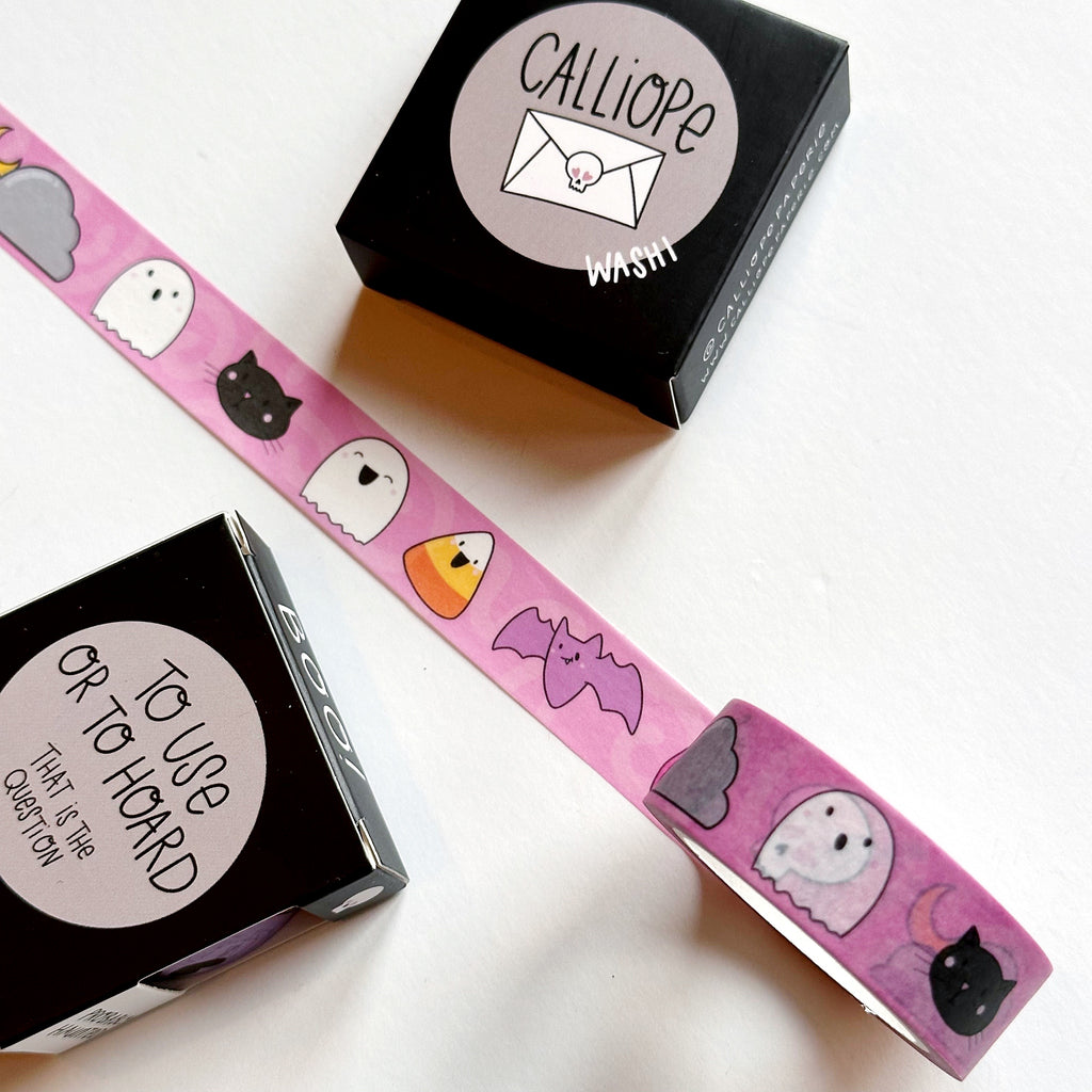 Image of Washi tape with pink background and images of purple bat, black cat, white ghost, candy corn, and grey cloud. 