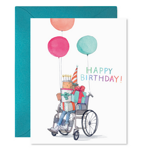 White background with image of a person in a wheelchair wearing a party hat and holding balloons and a pile of presents. Multicolored text says, "Happy Birthday!". Teal envelope included. 