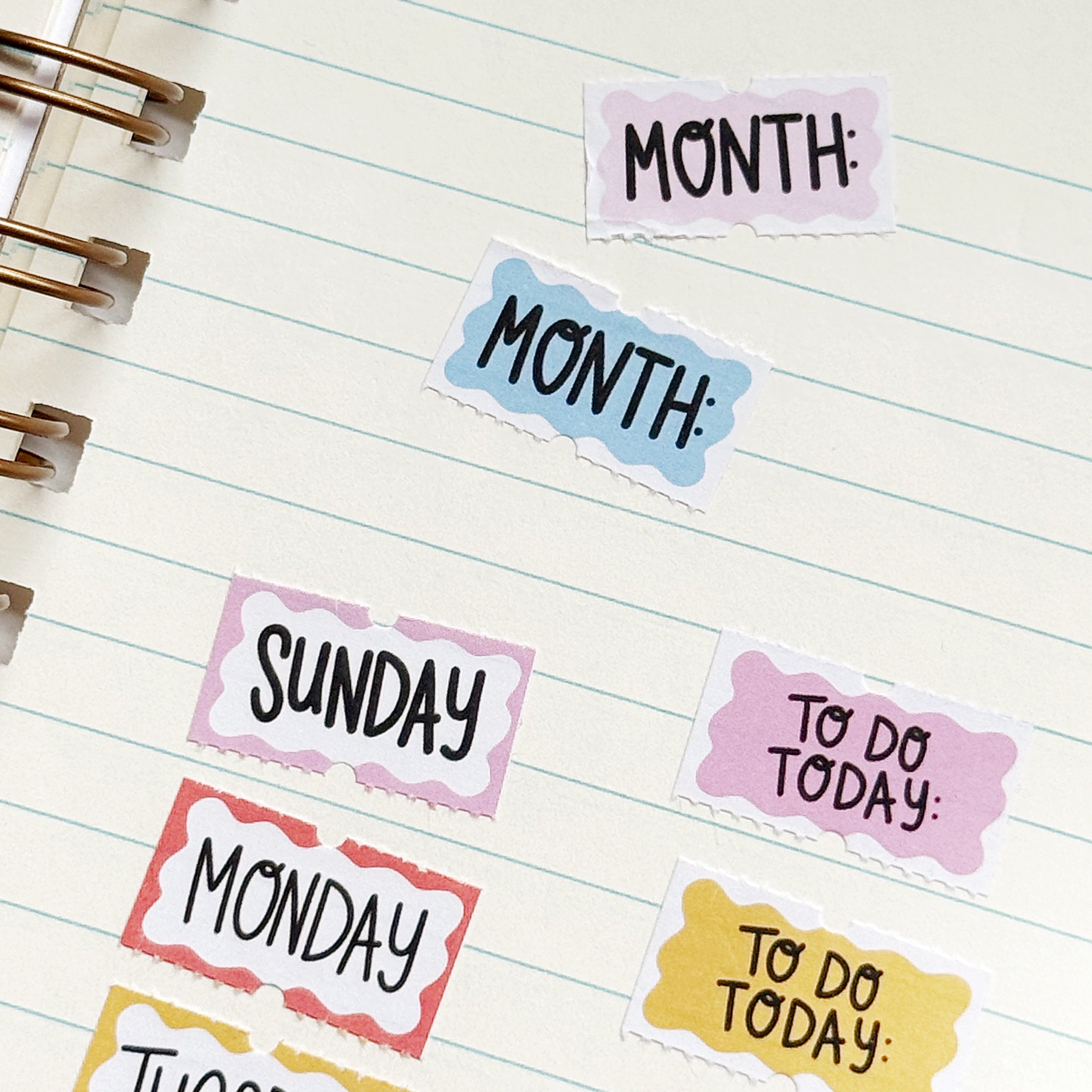 Small stickers with yellow, pink, white, blue backgrounds and black text says, "Sunday, Monday, Tuesday, Wednesday, Thursday, Friday, Saturday, To Do today, To do this week, Month".
