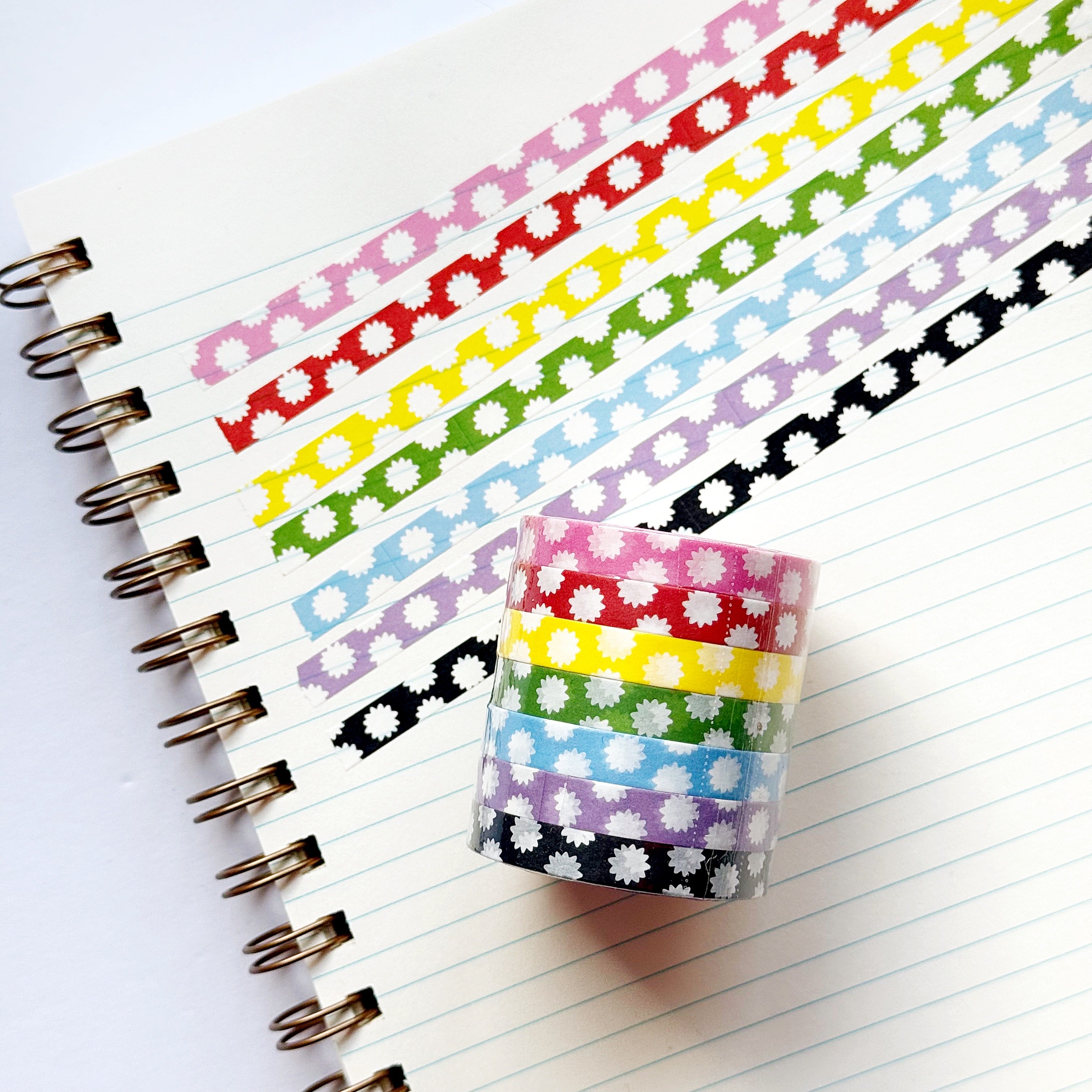 Decorative tape with micro starbursts in pink and white, red and white, yellow and white, green and white, blue and white, black and white and lilac and white.