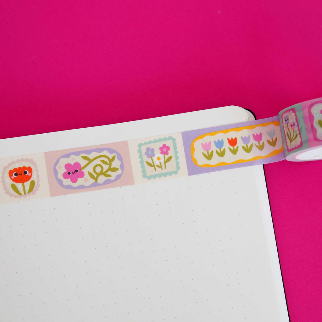 Washi tape with alternating pink, white and lilac backgrounds with flowers in pink, blue, red, lilac, yellow and green.