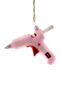 Image of a pink glue gun with red accents. 