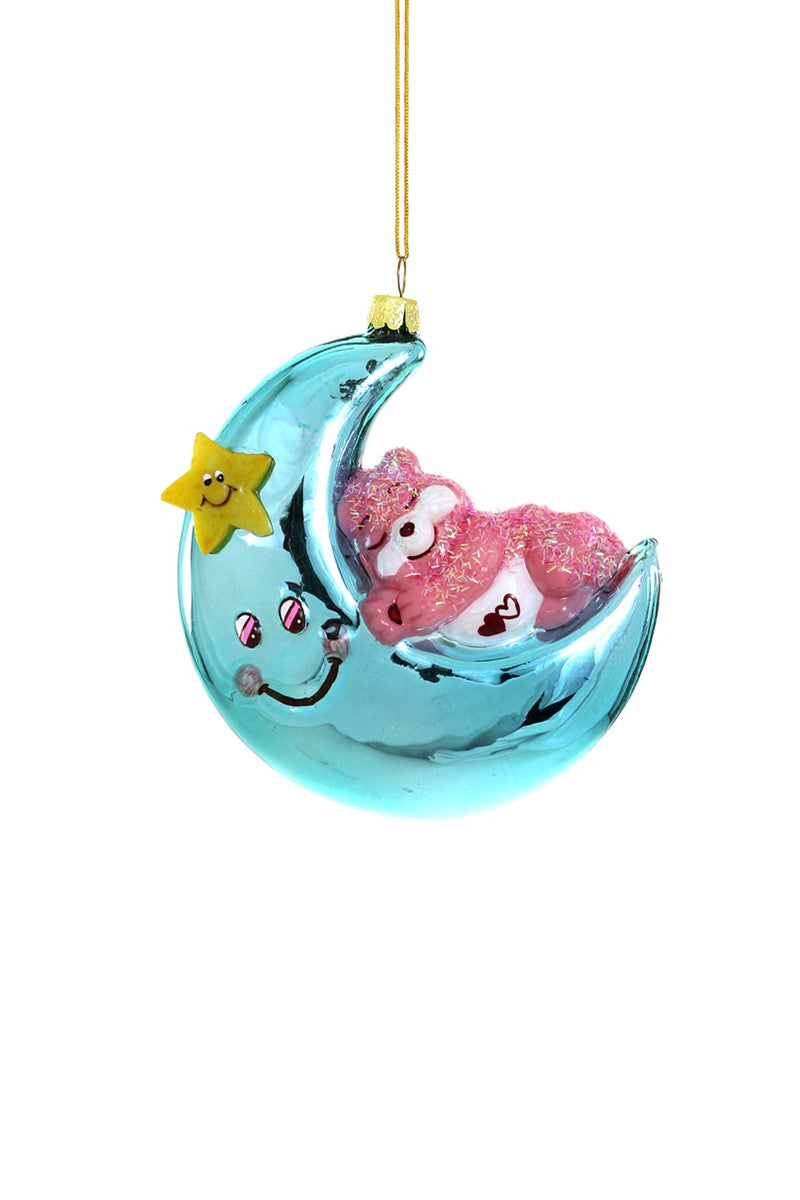 Image of pink sleepy Care bear on a blue crescent moon with yellow store. 