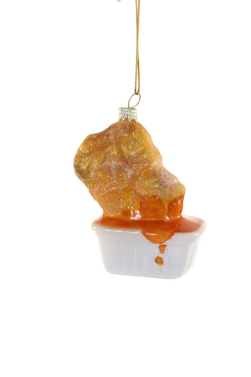 Image of golden chicken nugget with sweet and sour sauce and white cup.