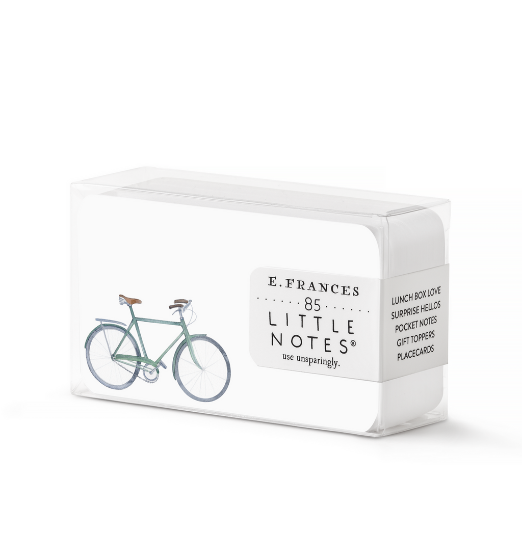 Image of box of little notes with white background and image of a light blue bicycle. 