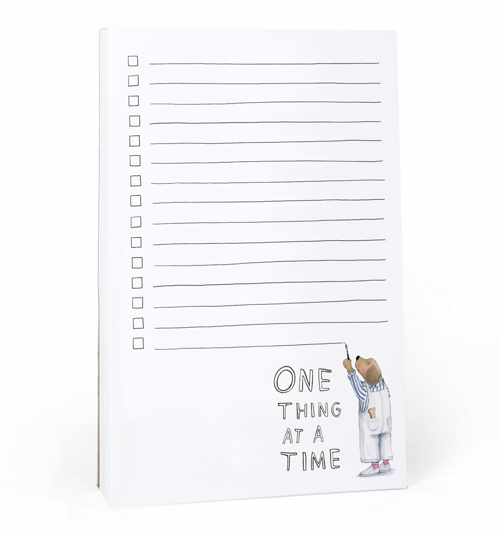 Image of notepad with white background and lines with checkboxes. Image of a dog in overalls painting the lines in black.  Black text says "one thing at a time". 