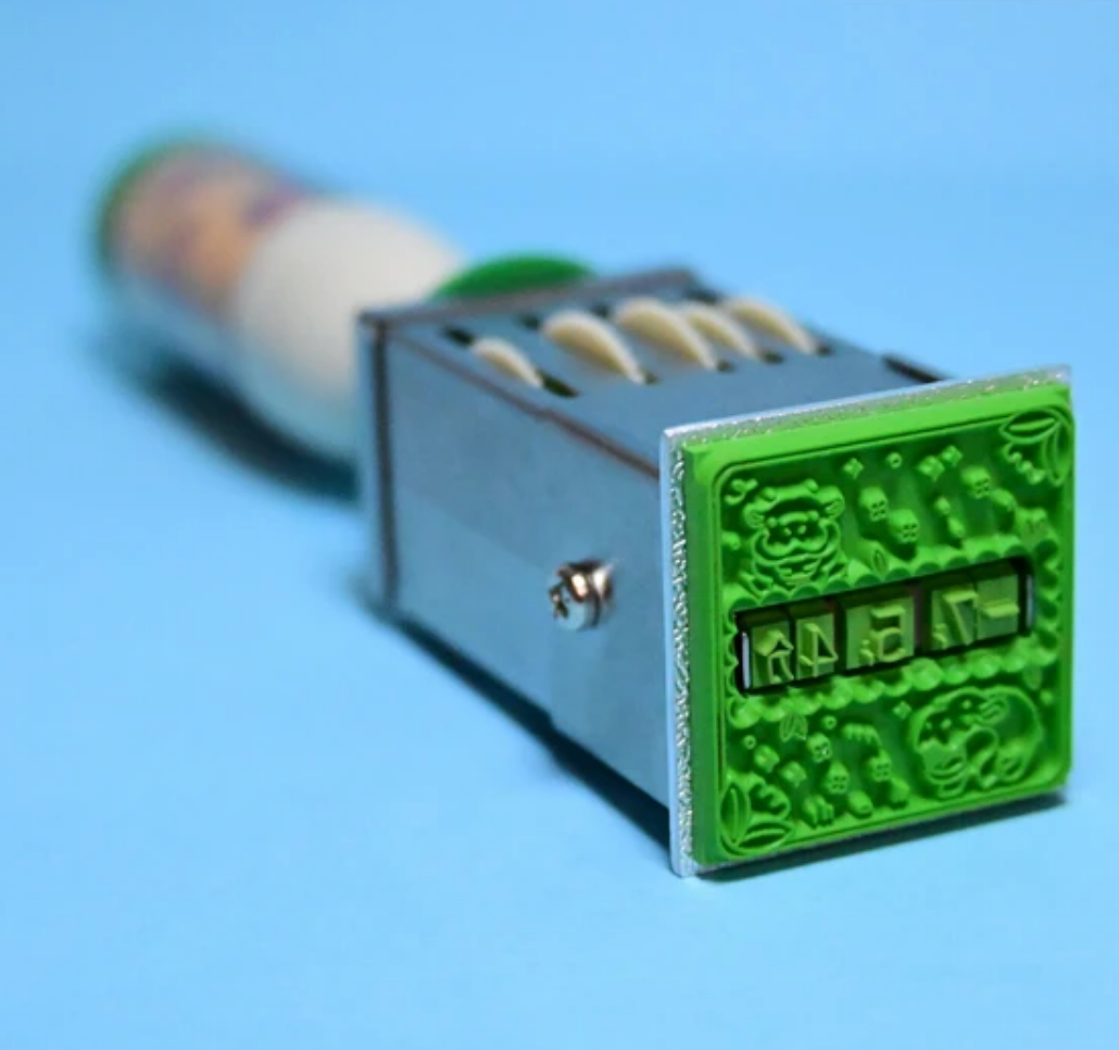 Image of stamper on its side with stamp showing.