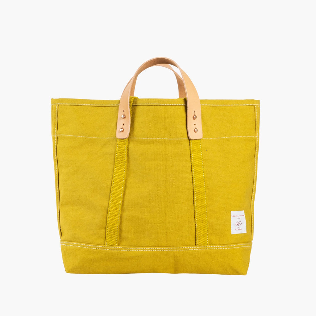 Tote bag in chartreuse with short leather handle and longer webbing shoulder strap. Inside pocket.