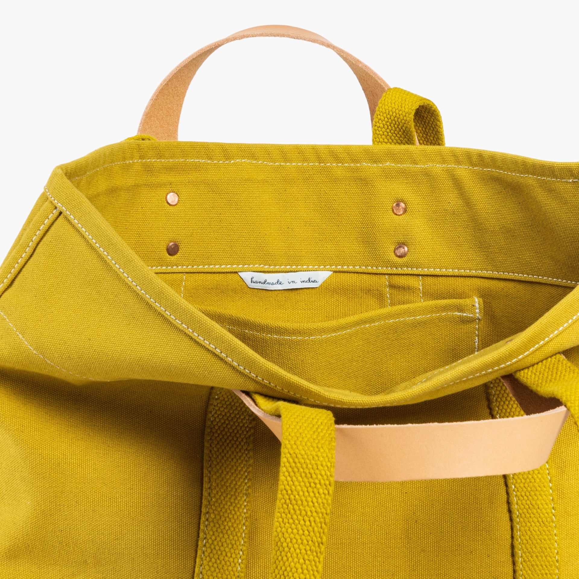 Tote bag in chartreuse with short leather handle and longer webbing shoulder strap. Inside pocket.