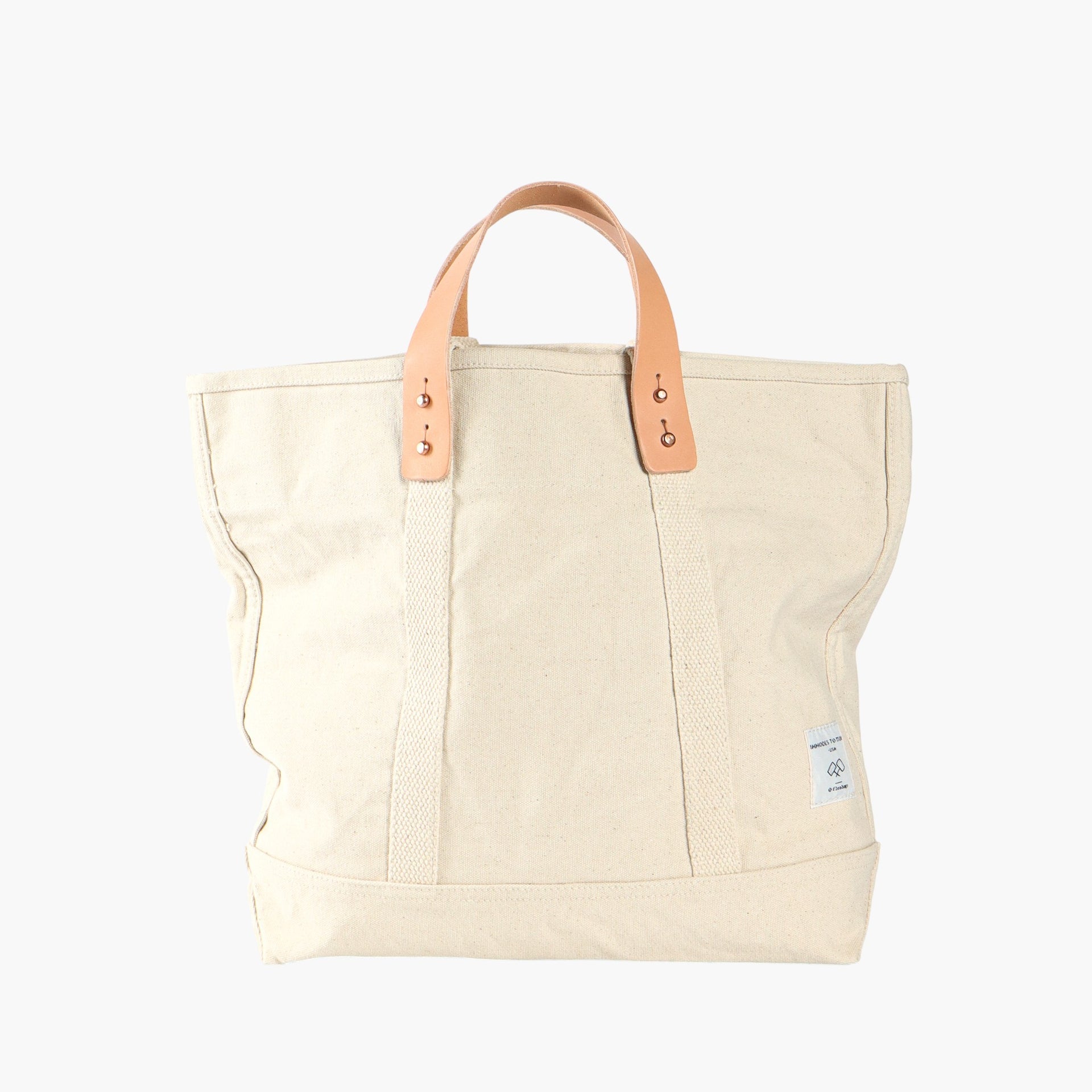 Ivory tote bag with short leather handles and longer ivory webbing handles.