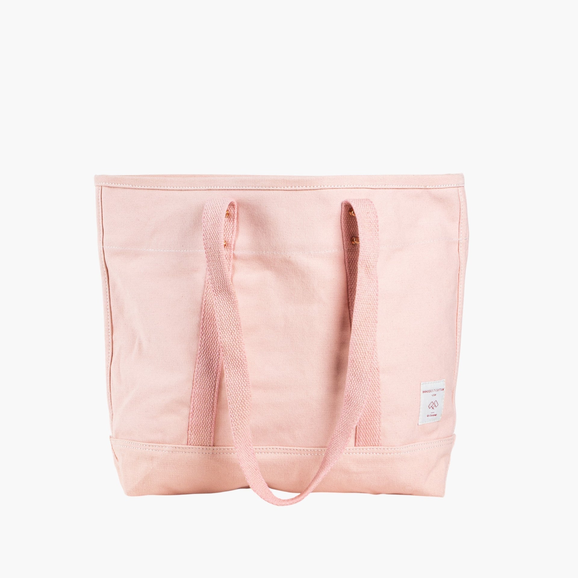 Pink tote bag with short leather handles and longer pink webbing shoulder straps. 