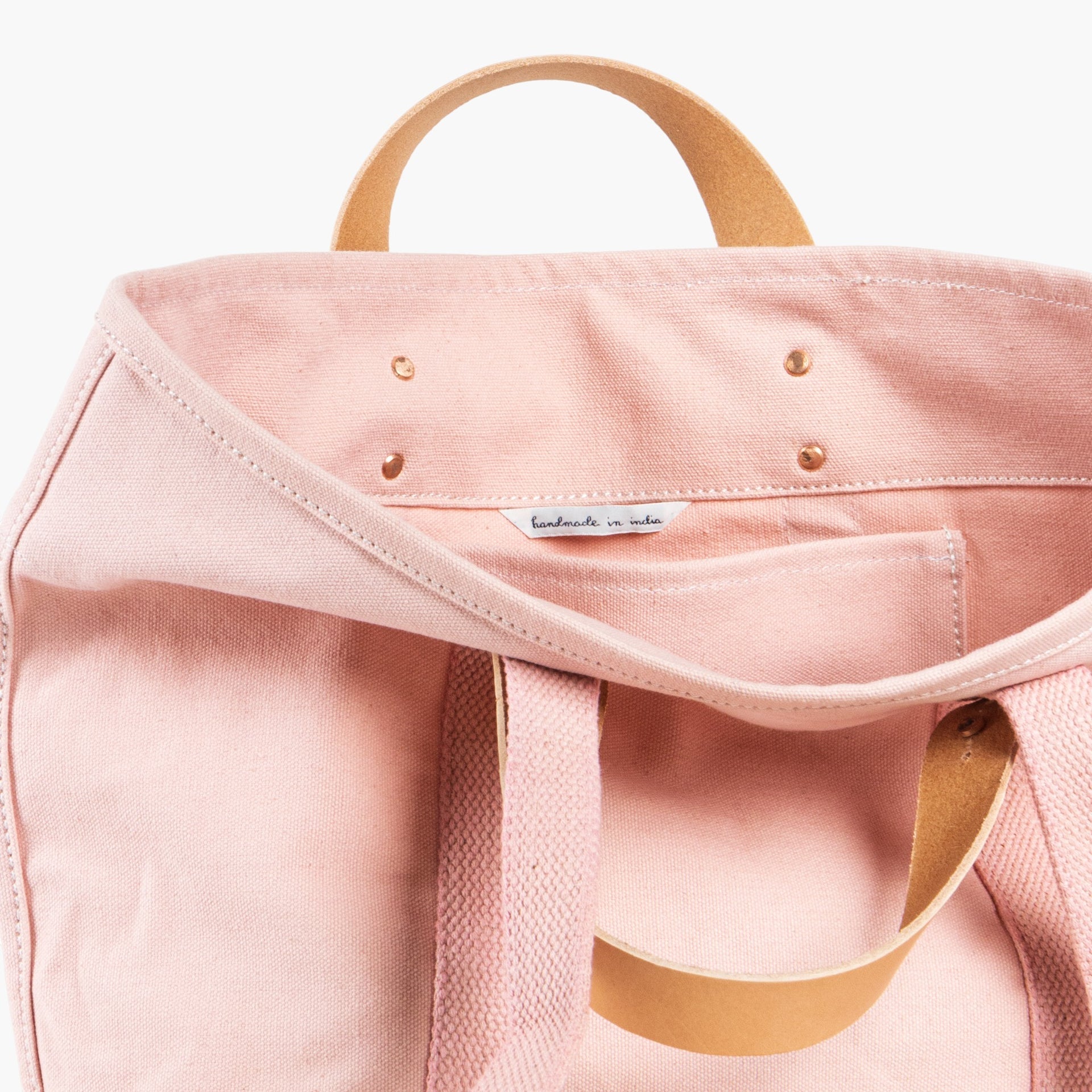 Pink tote bag with short leather handles and longer pink webbing shoulder straps. Inside pocket.