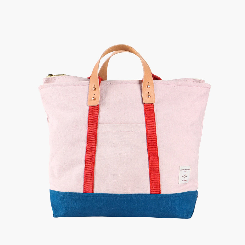 Tote bag in ivory with blue bottom and red webbing. Short leather handles.