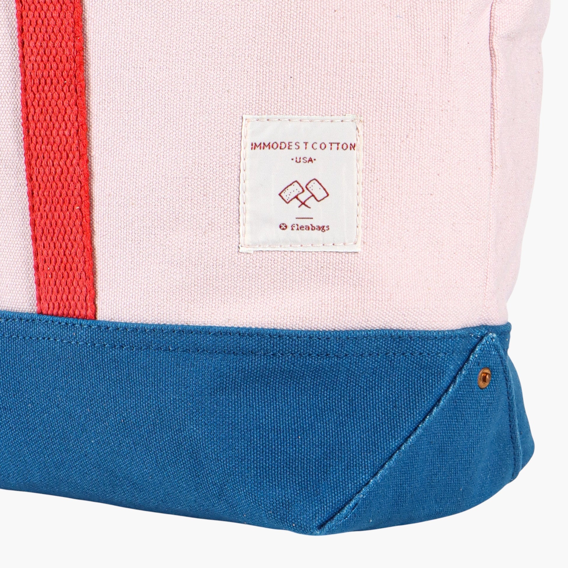 Corner of tote bag with label says, "immodest cotton, USA, fleabags".