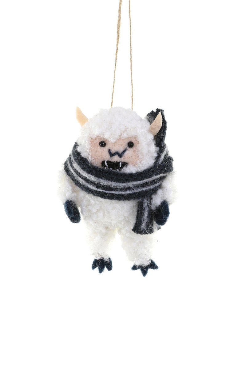 Image of a white yeti wearing a black and white scarf. 