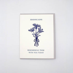 Greeting card with white background and mage of three flower stems and blue text says, "Sending love, Remembering them with you today". Envelope included. 