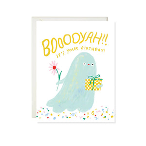 White background with image of pale blue ghost holding a gift and a flower with yellow text says, "Booooyah It's your birthday!". White envelope included. 